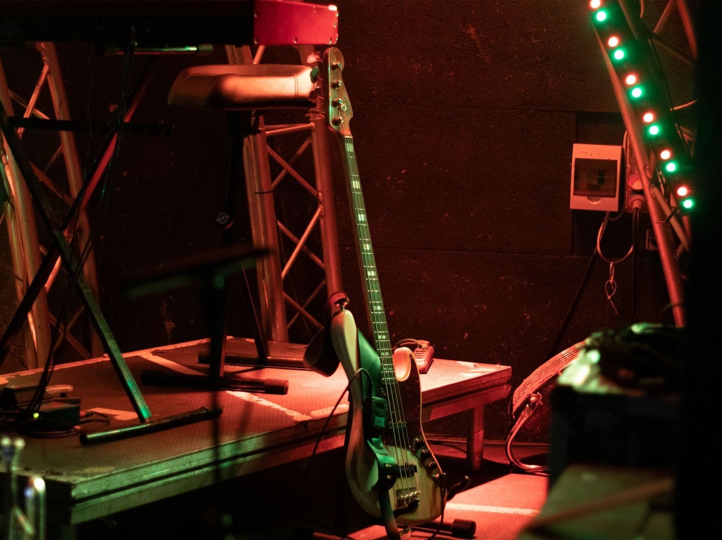 Bassgitarre und Bühnentechnik in rot-grüner Gothic-Metal-Beleuchtung