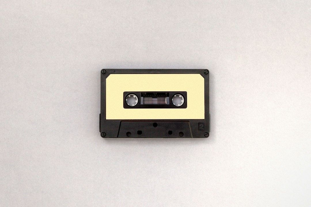 Schwarze Kompaktkassette mit hellem Etikett auf weißem Hintergrund